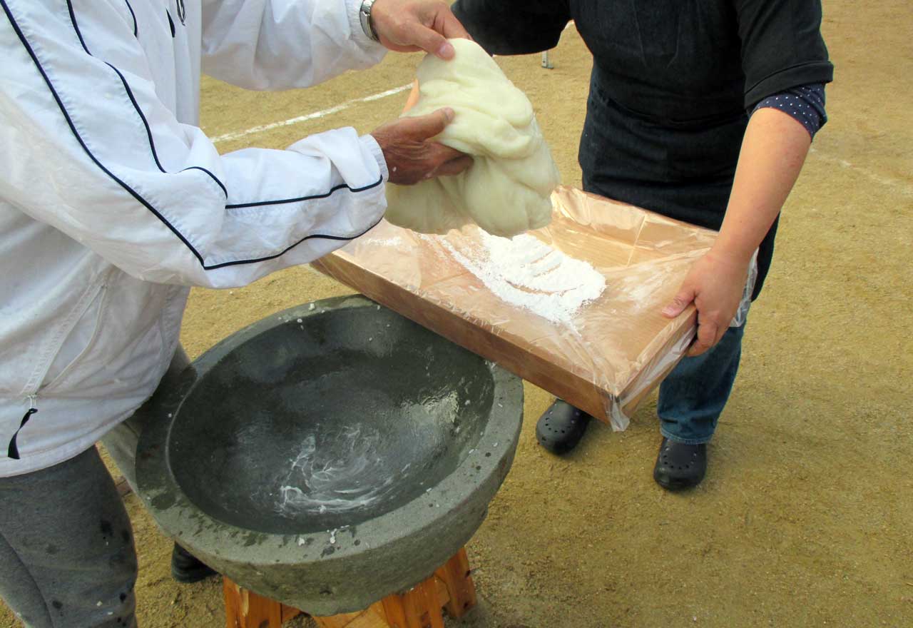 man holding a giant glob of fresh mochi